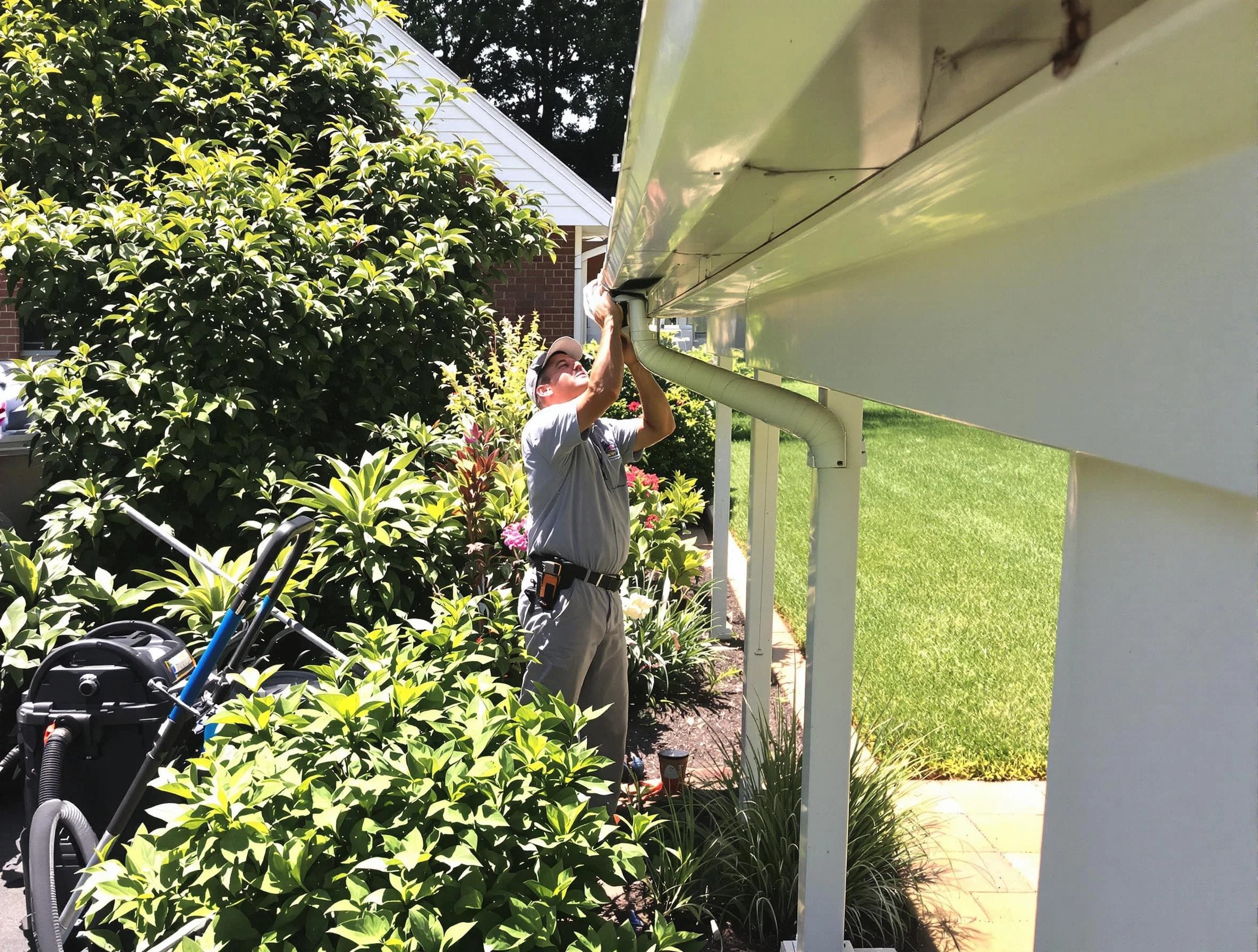 Technician flushing a blockage from a downspout in Rocky River, OH